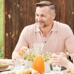 A cheerful family enjoying an outdoor meal together in a warm setting.
